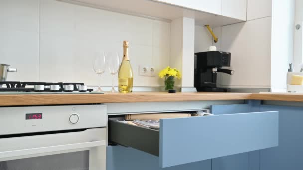 Mans mão fechando uma gaveta na moderna cozinha azul-teal e branco - Filmagem, Vídeo