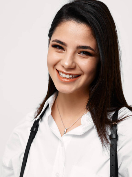happy woman in white shirt with suspenders laughs and makeup on face - Fotografie, Obrázek