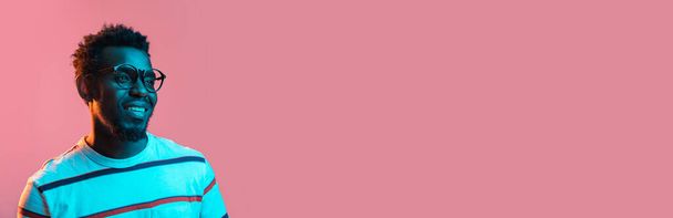 Detailní záběr mladý afroameričan izolované na růžovém pozadí v neonu - Fotografie, Obrázek