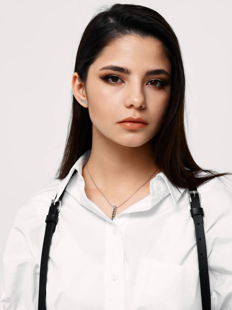 sexy brunette in een wit shirt op een lichte achtergrond modieus kapsel model - Foto, afbeelding
