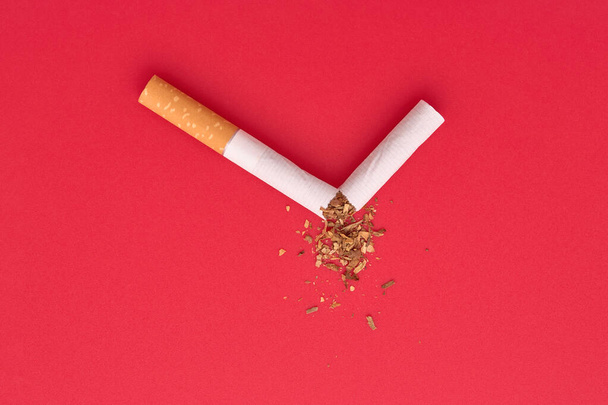 Sigarayı bırakmak için kırık bir sigara ve dağınık tütün.. - Fotoğraf, Görsel