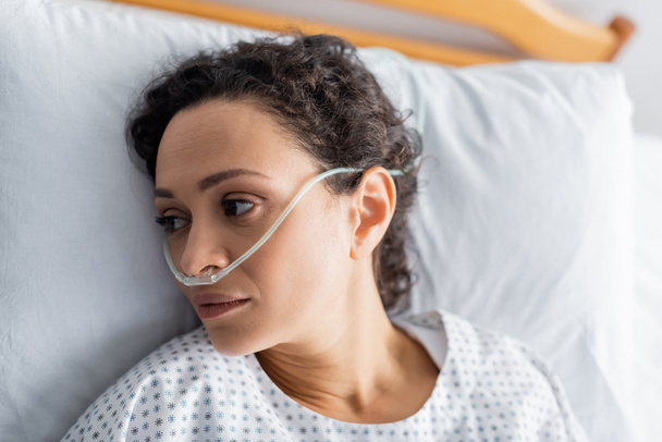 top view of ill african american woman lying with nasal cannula in hospital - Photo, Image