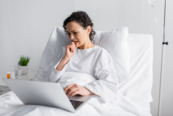 nervous african american woman looking at laptop in hospital - 写真・画像