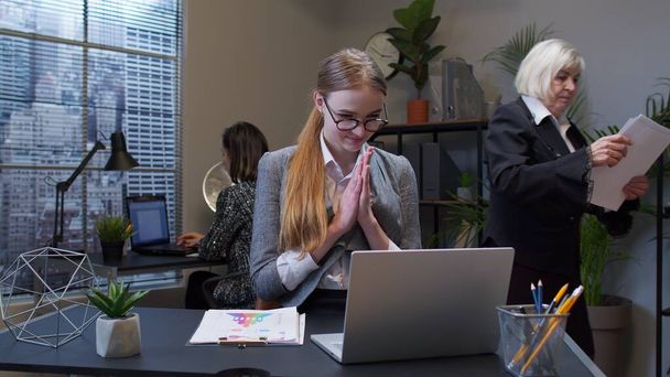 Jeune femme d'affaires rusée frottant les mains complotant le plan de farce délicat maléfique à l'esprit dans l'intérieur du bureau - Photo, image