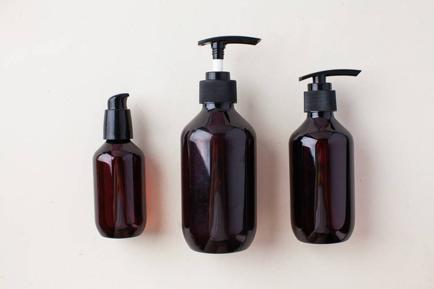 Drie verschillende bruine flessen met natuurlijke biologische cosmetica producten. Natuurlijke nul afval huidverzorging concept - Foto, afbeelding