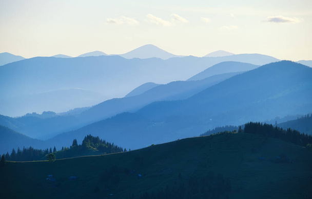 山脈の眺め。夏時間の日没時の風景。山岳地帯の霧の丘。旅行のイメージ。春の風景. - 写真・画像