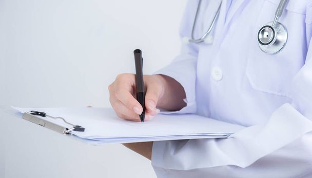 Lékař rukou s vědomím informace o pacientovi v papírování kontrolní seznam na schránce s bílým pozadím - Fotografie, Obrázek