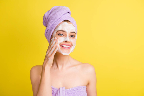 Close-up portrait of pretty cheerful girl using soap mask cleansing pore isolated over bright yellow color background - 写真・画像