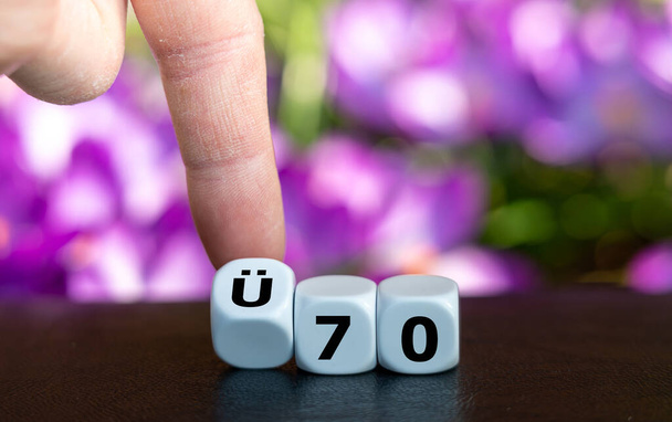 Würfel bilden den deutschen Ausdruck "UE 70" (über 70 Jahre alt) als Symbol für Menschen über 70 Jahren. - Foto, Bild