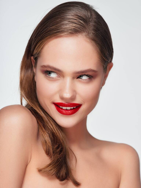 hermosa rubia con labios rojos hombros desnudos fondo claro - Foto, imagen