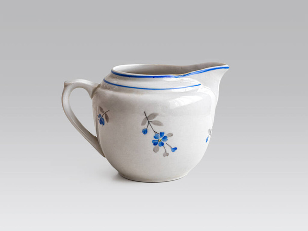 Milchmann aus Porzellan - ein Gefäß für Milch oder Sahne, ein Gegenstand für Tee oder Kaffee, birnenförmig auf hellem Hintergrund - Foto, Bild