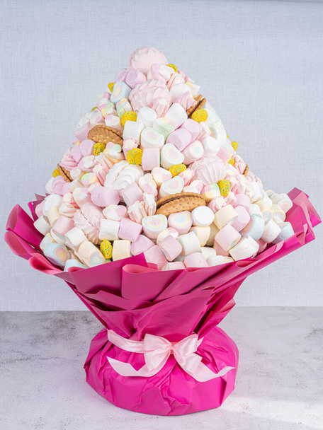 O buquê doce de doces de Marshmallows, belamente decorado, está em um fundo cinzento.Conceito de férias, congratulações. - Foto, Imagem
