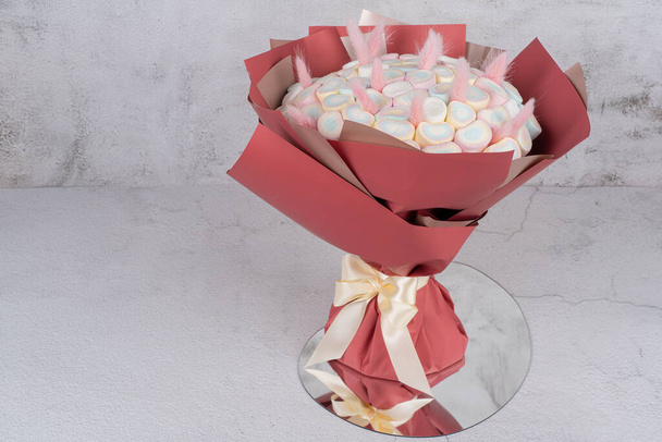 Dolce bouquet di dolci marshmallow, splendidamente decorato, si trova su uno sfondo grigio. C'è un posto per tex - Foto, immagini