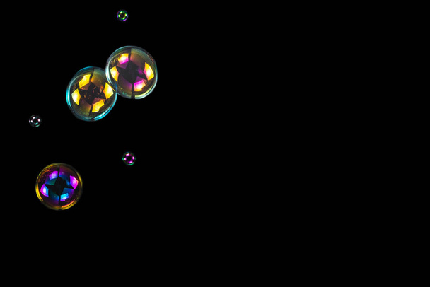 Мильні бульбашки ізольовані на чорному тлі. Копіювати простір
.  - Фото, зображення