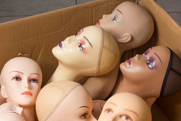 Паперова коробка з жіночими головами манекенів з макіяжем без волосся. Доставка товарів для покупок під час коронавірусу. Магазин комерційного обладнання
. - Фото, зображення