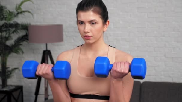 Atletická žena dělá biceps kadeře s činkami, cvičení doma v ložnici - Záběry, video
