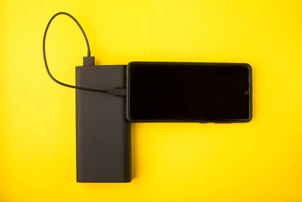 Power bank on a colored background. External battery for recharging. - Photo, Image