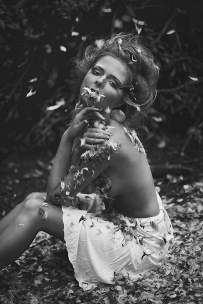 Beautiful naked girl in a forest with feathers - Photo, Image