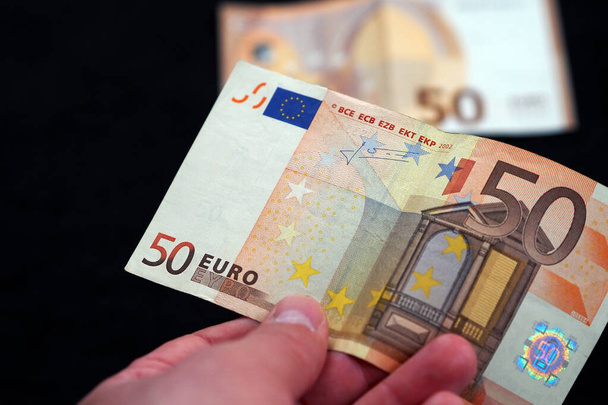 nieuwe en oude 50 eurobankbiljetten staan op zwarte achtergrond, - Foto, afbeelding