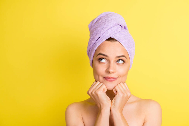 Close-up portrait of pretty minded girl wearing turban on head thinking copy space choose isolated over bright yellow color background - 写真・画像
