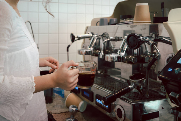 Personel Barista przygotowuje kawę, pracując z ekspresem do kawy w kawiarni lady bar. - Zdjęcie, obraz