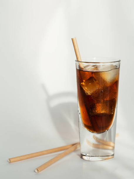 Glass of cola with ice and straw on white background - Foto, imagen