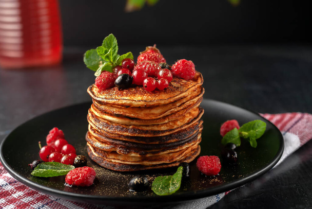 Delicious homemade pancakes with fresh raspberries, currants and strawberries - Foto, Imagen