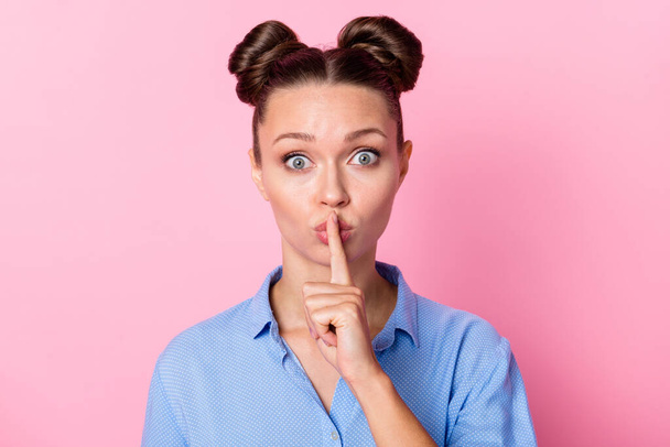 Photo portrait of speechless girl with top-knot hairstyle keeping finger near lips secret staring isolated on pastel pink color background - Foto, Bild