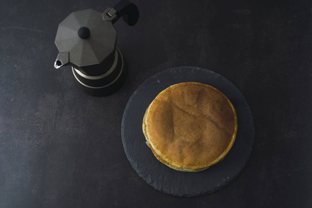 A top view of pancakes and coffee on a black background - Foto, Bild