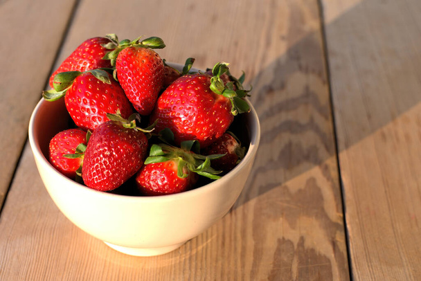 Freshly harvested ripe strawberries ,in a wooden bowl. Close up - Foto, Imagem