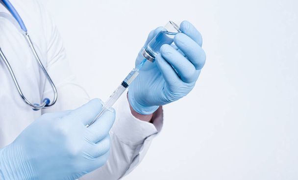 il medico tiene in mano una siringa e un vaccino contro il virus - Foto, immagini