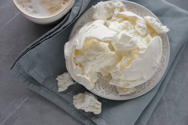 Large meringue on a plate and a blue napkin - Photo, image