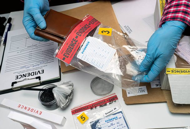 Policial especializado leva carteira com dinheiro de um saco de provas de homicídio, imagem conceptual - Foto, Imagem