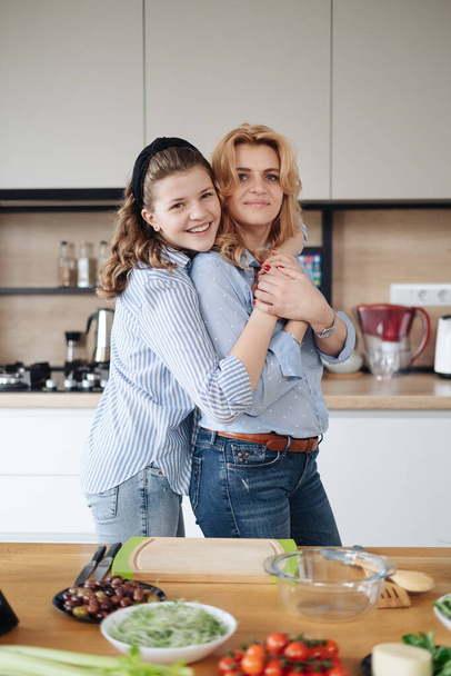 Mother and daughter teenager cooking together - Zdjęcie, obraz
