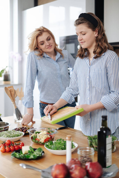 Mother and daughter teenager cooking together - 写真・画像