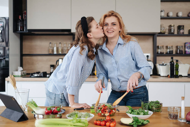 Mother and daughter teenager cooking together - Valokuva, kuva