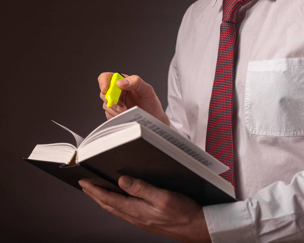 Obchodník ruce drží tlustou knihu práva v rukou v košili přes černé pozadí. Koncept MBA - Fotografie, Obrázek