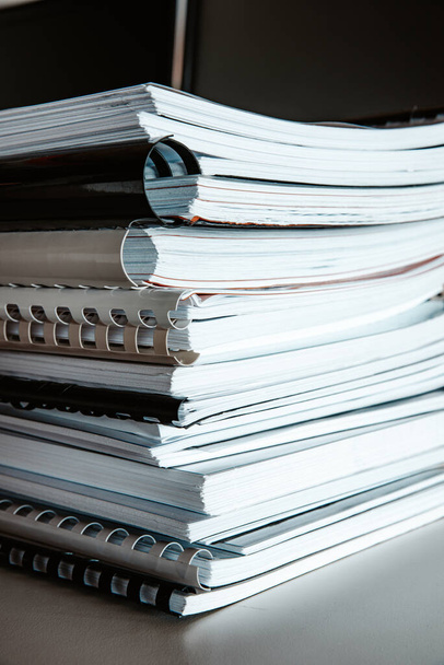 Stack of reports lies on a desk ready for review - Photo, Image