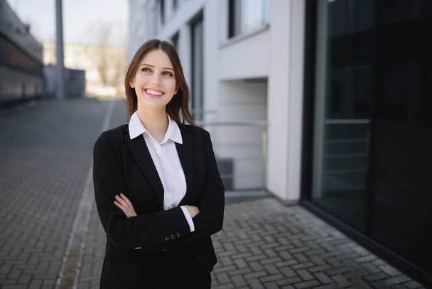 A beautiful woman in a business suit crosses her arms and looks away - Foto, Bild