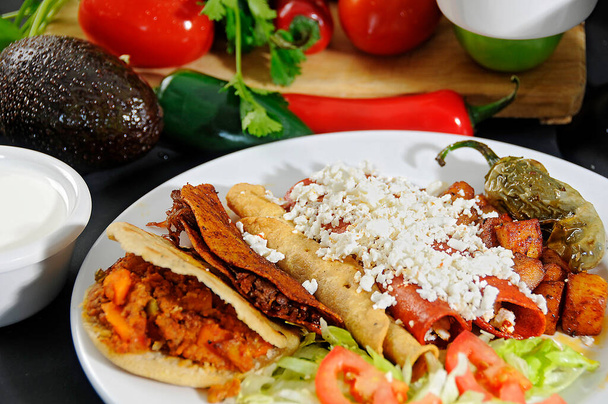 Comida tpica Mexicana, gorditas, tacos dorados, enchiladas rojas con ensalada y chiles toreados - 写真・画像