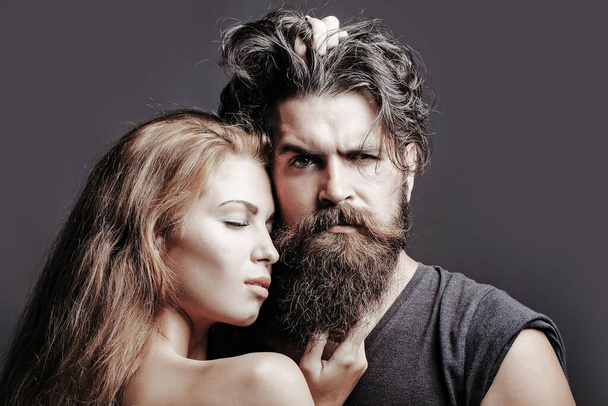 Portrait of sexy couple embracing. Bearded handsome man and female slim flexible body of young pretty sexy woman or girl with bare back. - Фото, зображення