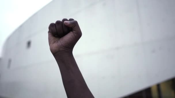 人種主義に対する抗議でアフリカ系アメリカ人の拳を上げました-黒人生活問題の抗議でサポートを示す男の握り拳(BLM).-終わりだ - 映像、動画