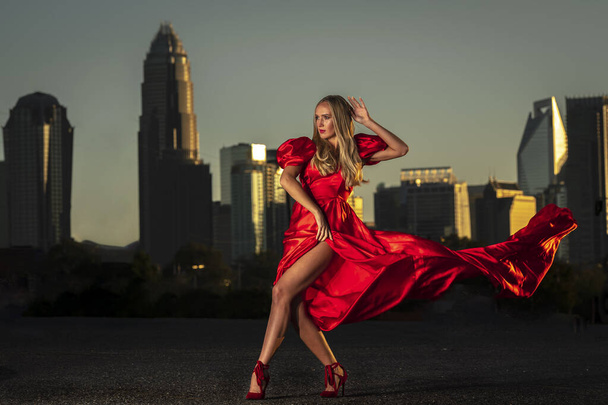 A gorgeous blonde model poses outdoors in her evening dress - Photo, Image