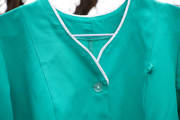старый медицинский костюм висит на вешалке на улице в Украине, униформа медсестры - Фото, изображение