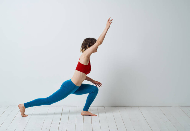 Sportieve vrouw in een lichte kamer en doet Yoga Asana oefeningen - Foto, afbeelding