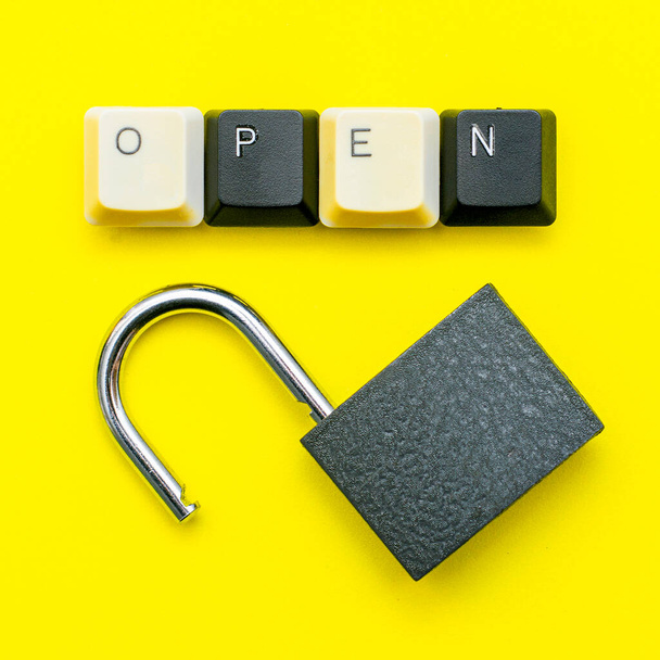 serrure ouverte sur fond jaune le mot concept ouvert est disposé sur le dessus d'un clavier d'ordinateur. Photo de haute qualité - Photo, image