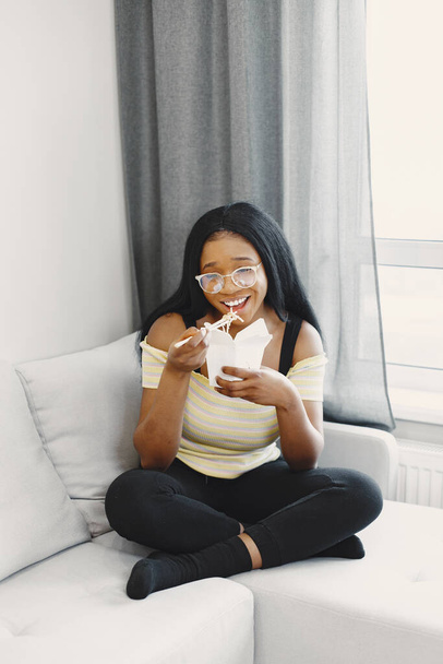 Прекрасна африканська американка, яка їсть локшину. - Фото, зображення