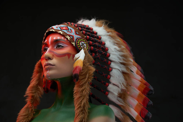 黒の背景に伝統的な帽子をかぶった西洋の部族の女性 - 写真・画像