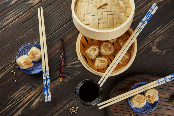 Shumai shaomai kiinalainen liha nyytti höyrytetty ruokalaji bambu höyrylaiva laatikko. Syömäpuikot ja himmennys. - Valokuva, kuva
