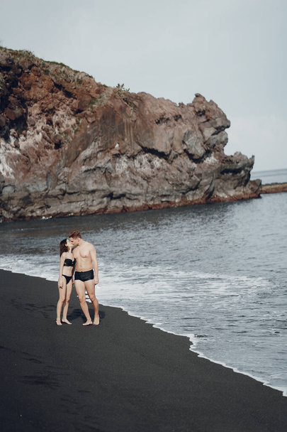 Elegant couple on a beach near rocks - Foto, afbeelding